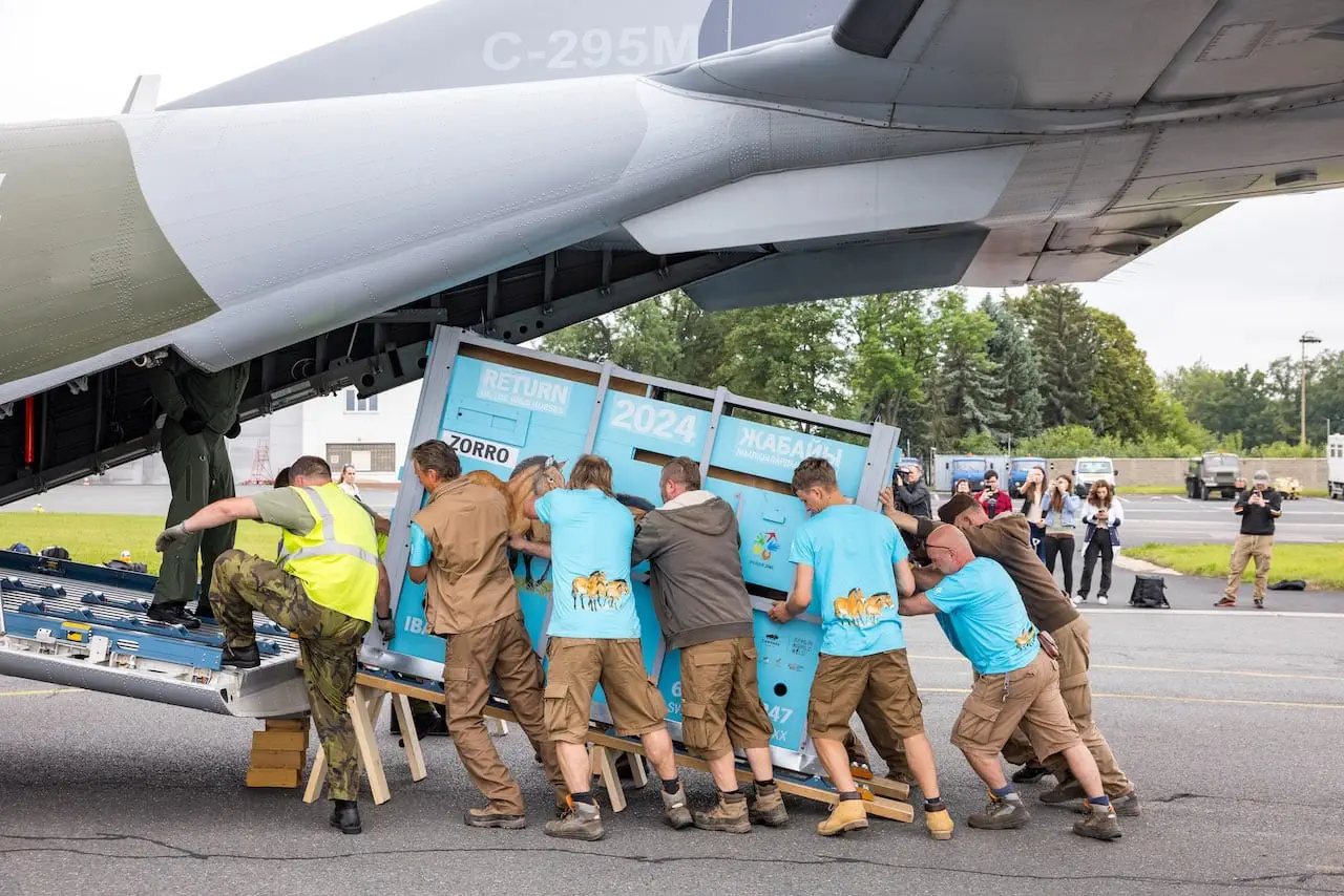 A team of conservationists pushes a blue crate labeled 