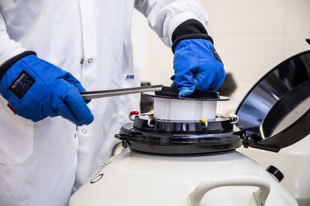 Close up image of scientist removing samples from a biobank